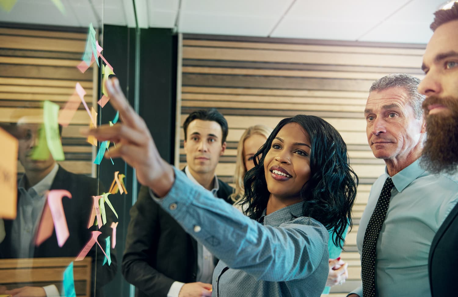 A leadership team in conversation around a strategy board